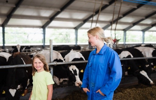 Lantbrukare och barn som ser till sina mjölkkor