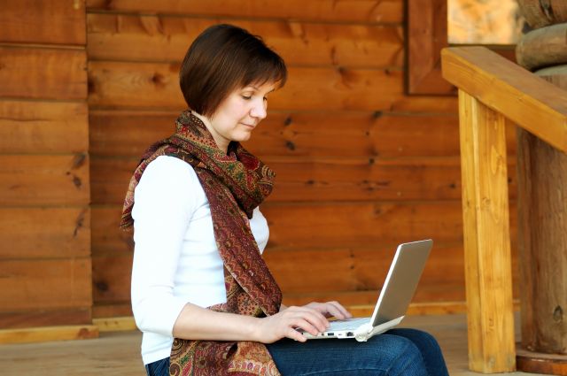 Tjej som sitter på utetrappan med laptop i knäet, teknik, IT, människa